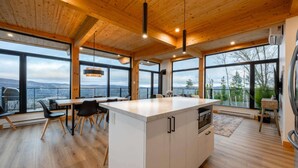 Una cocina moderna con ventanas amplias, techo de madera y una isla central.