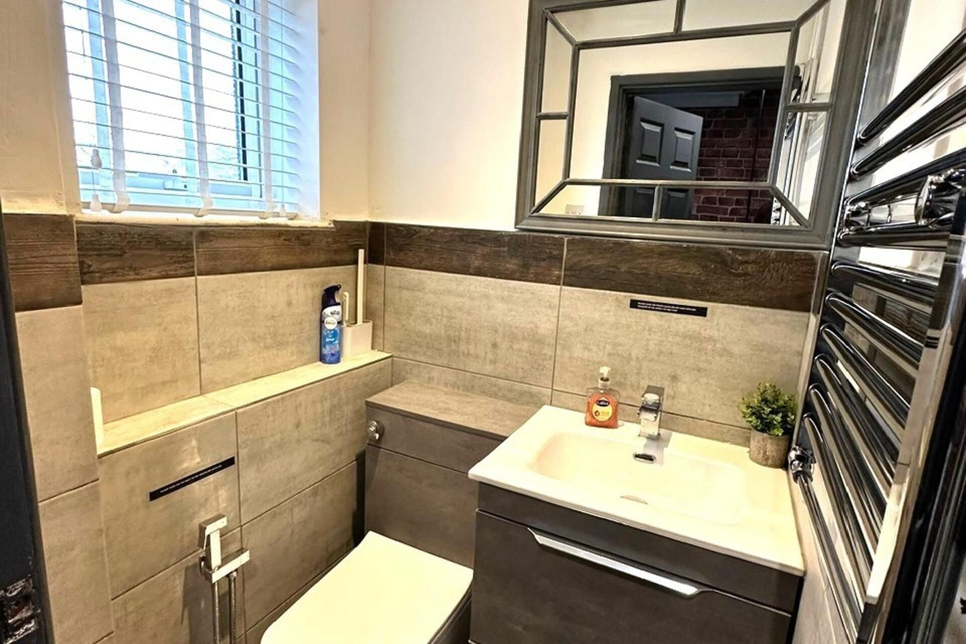 A modern bathroom with a shower, a sink, and a mirror.