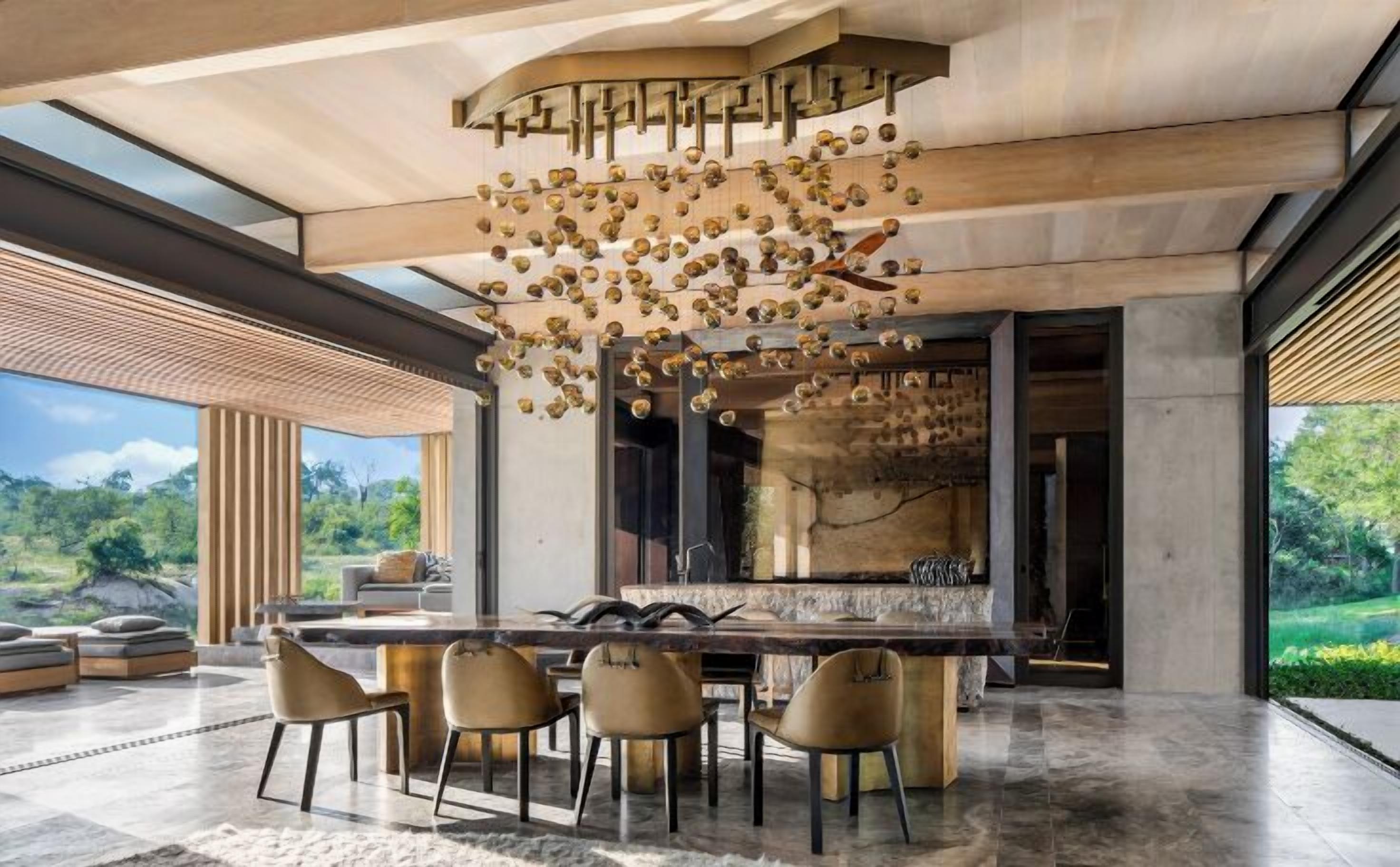 A modern kitchen with a large island, pendant lighting, and a view of the outdoors.