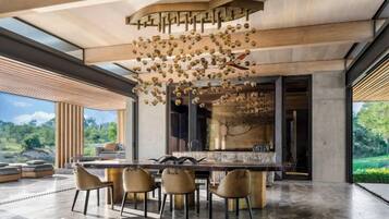 A modern kitchen with a large island, pendant lighting, and a view of the outdoors.