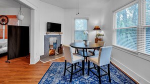 A dining area with a round table, chairs, and a blue patterned rug. - C.a.l.m. Cottage At The Last Mile 2 Bedroom Home (Savannah)