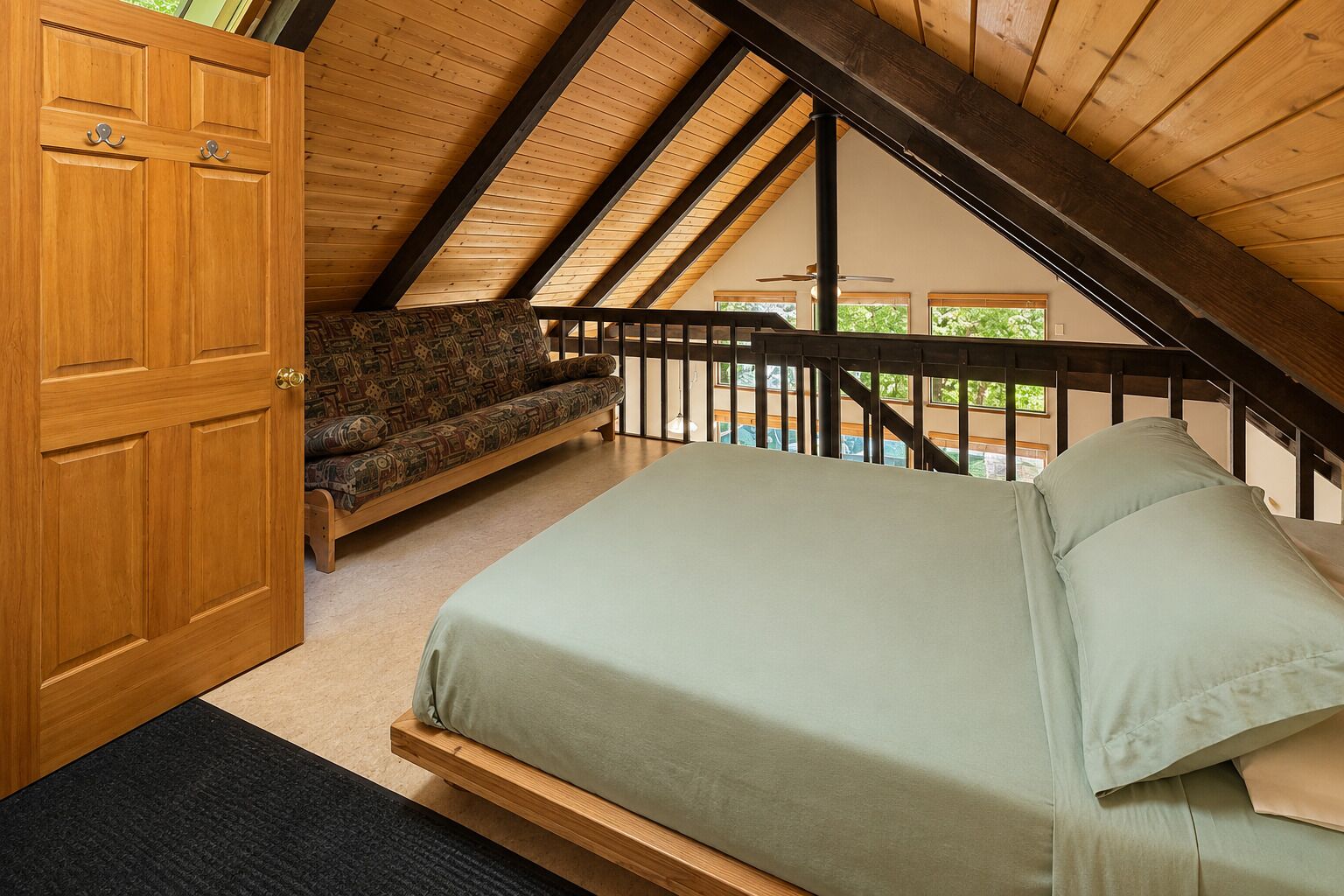 Un dormitorio con una cama, un sofá y una puerta de madera.