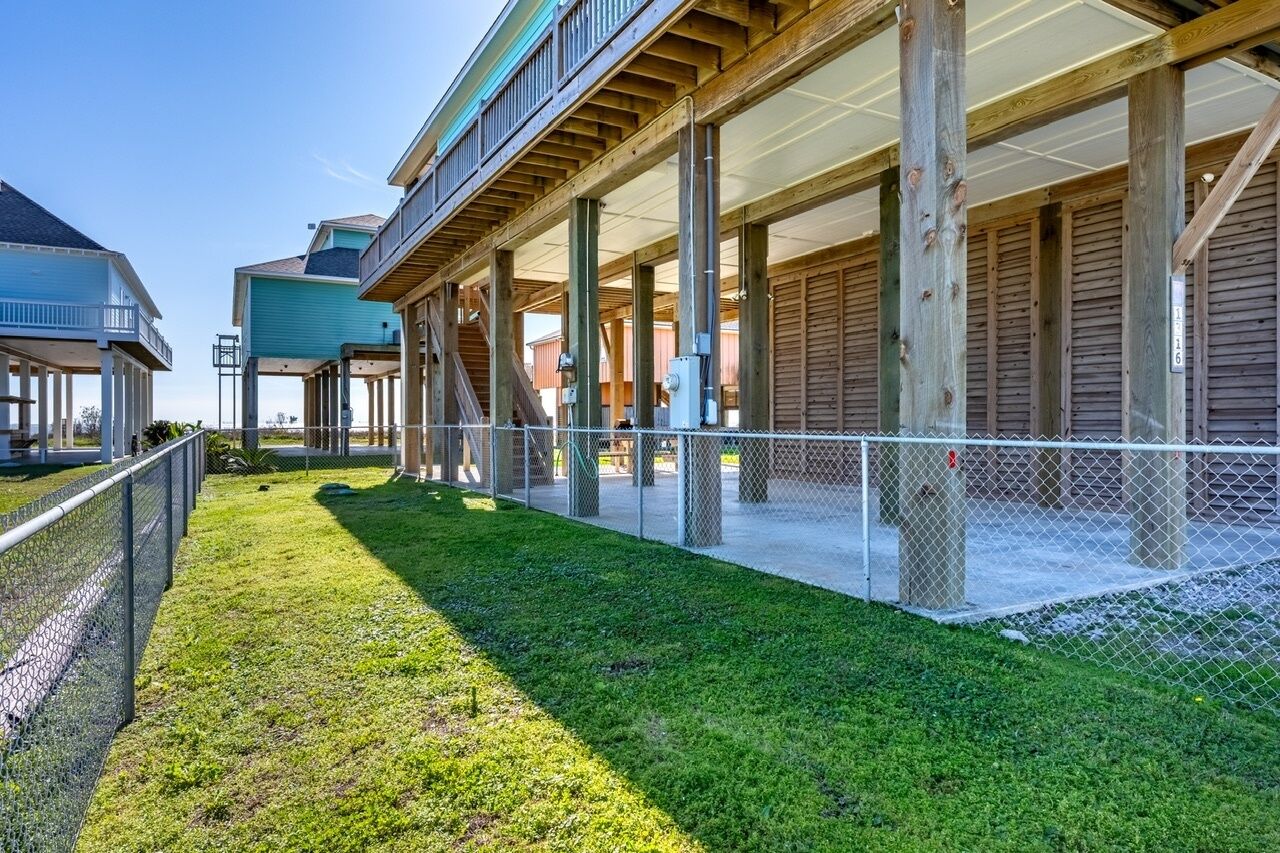 A covered outdoor area with wooden beams and a metal fence, likely a patio or deck area.