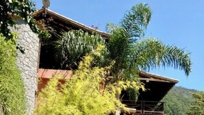 A two-story building with a stone facade, surrounded by lush greenery and a swimming pool. - Itaipava House (Itaipava)