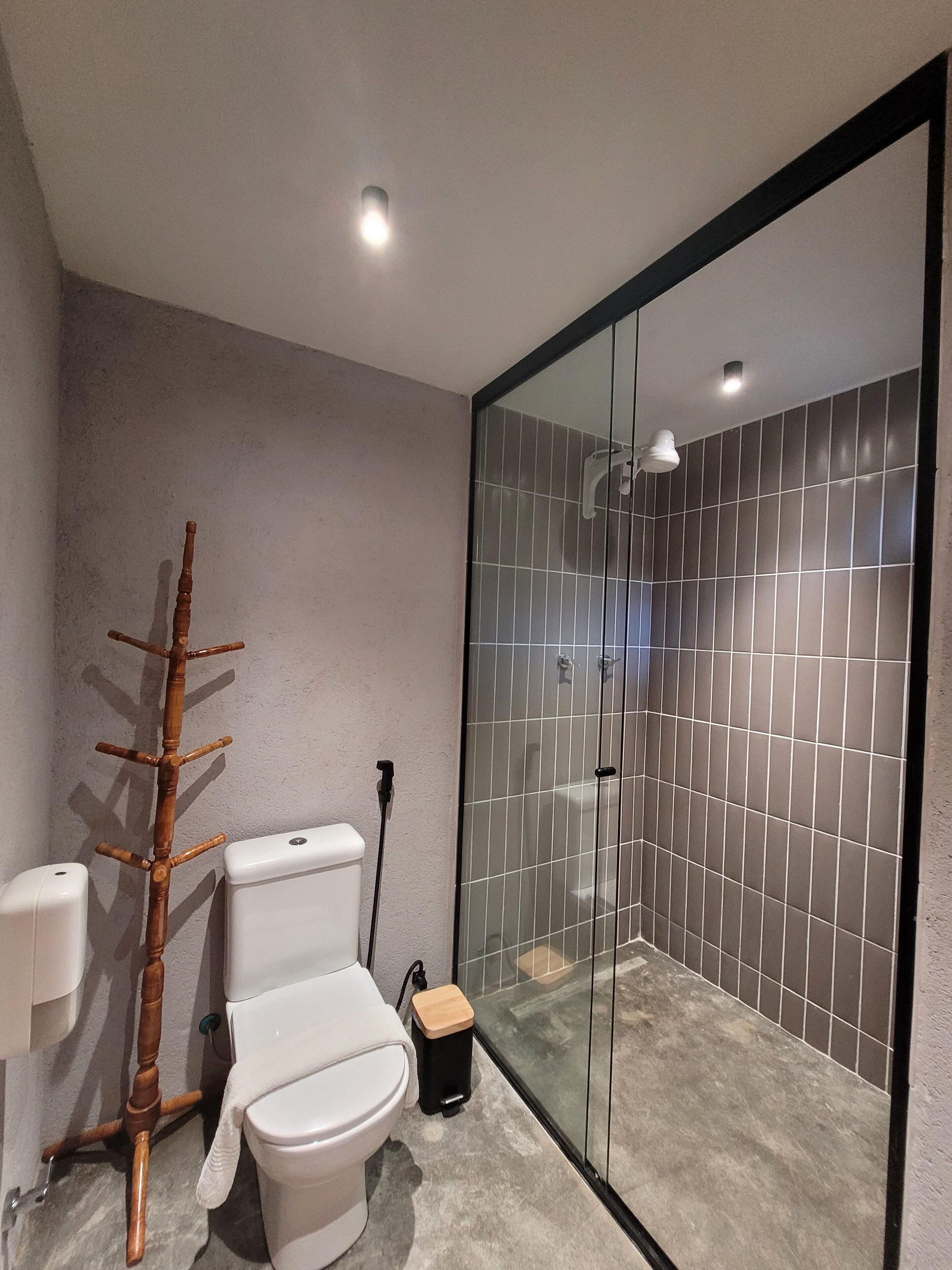 A modern bathroom with a toilet, bidet, and a glass shower enclosure.