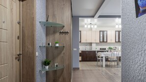 Una cocina moderna con armarios de madera, un comedor y un pasillo con puerta de madera.