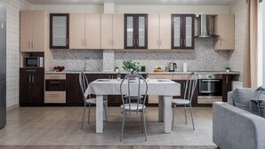 Una cocina moderna con una mesa de comedor, sillas y un horno empotrado.