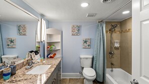 A bathroom with a sink, two toilets, a bathtub, and a shower. - New Heated Pool & Hot TUB!  Direct Pool Access (Galveston)