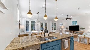 A modern kitchen with granite countertops, stainless steel appliances, and blue cabinetry. - New Specials! 6 Seater Cart, Bikes & Beach Toys, Gated Beach Community (SANTA ROSA BEACH)