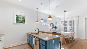 A spacious kitchen with a central island, wooden flooring, and pendant lighting. - New Specials! 6 Seater Cart, Bikes & Beach Toys, Gated Beach Community (SANTA ROSA BEACH)