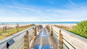 A wooden boardwalk leading to a beach with a clear sky. - Admiral's Quarters #1406 | Gulf Front + Amenities (Orange Beach)