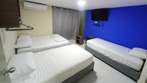 Een hotelkamer met twee eenpersoonsbedden, een aan de muur bevestigde televisie en een airconditioning.
