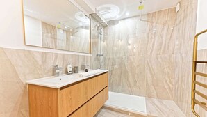 A modern bathroom with a marble shower, a wooden vanity, and a large mirror. - Sublime air-conditioned flat Galeries Lafayette (Paris)