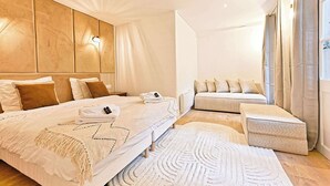 A modern bedroom with a large bed, a sofa bed, and a small table. - Sublime air-conditioned flat Galeries Lafayette (Paris)