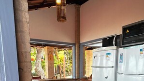 Une cuisine avec un comptoir en bois, un réfrigérateur et une vue sur l’extérieur.