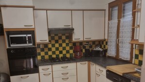 A kitchen with white cabinets, a microwave, a coffee maker, and a dishwasher. - House in quiet area 1km from the sea and 300 m from shops (Saint-Palais-sur-Mer)