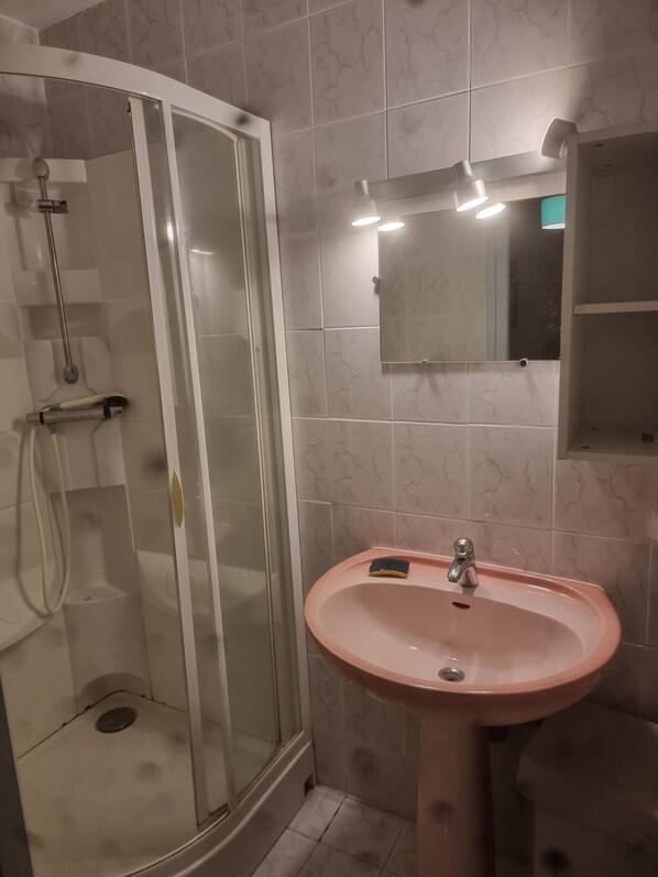 A bathroom with a glass-enclosed shower, a pink sink, and a mirror above it. - House in quiet area 1km from the sea and 300 m from shops (Saint-Palais-sur-Mer)