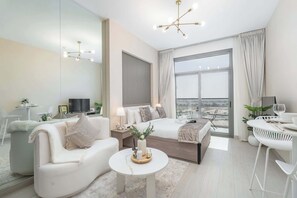 Relax in a spacious room with a large bed, sofa, and dining area, offering a city view and a flat-screen TV.