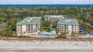 A beachfront hotel with multiple buildings, a pool, and a beach view. - 2 BDR w/Water Views, Beach Access, & Shared Pool! (Hilton Head Island)