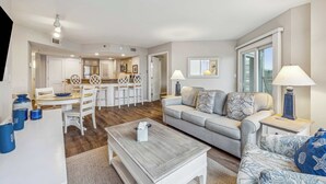 A modern living room with a sofa, coffee table, and dining area. - 2 BDR w/Water Views, Beach Access, & Shared Pool! (Hilton Head Island)