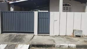 A residential building with a gated entrance, a water tank on the roof, and a small window. - Private pool house (Abrantes)