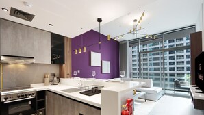 Una cocina moderna con una isla central, electrodomésticos integrados y un amplio ventanal con vistas a la ciudad.