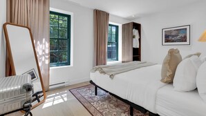 A hotel room with a bed, a mirror, a wardrobe, a window, and a painting on the wall. - Mercer-King Bedroom -Free parking (Montréal)