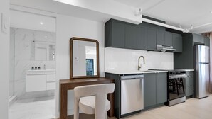 A modern kitchen with grey cabinets, a white countertop, and a built-in dishwasher. - Mercer-King Bedroom -Free parking (Montréal)