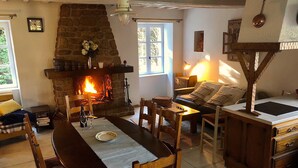 Una sala acogedora con chimenea, una mesa de comedor y un sofá.