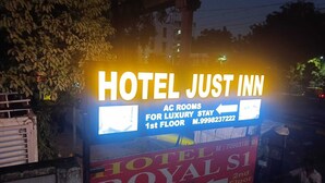 A sign for Hotel Just Inn advertising AC rooms on the 1st floor. - Hotel just inn (Ahmedabad)