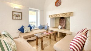 Una sala de estar acogedora con un sofá, una mesa de madera y una chimenea.