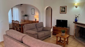 A living room with a sofa, TV, fireplace, and dining area. - LA CASITA | ideal villa for small families | 2 double bedrooms | private pool (Teulada)