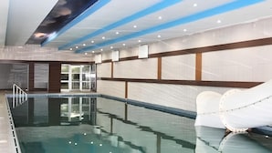 An indoor swimming pool with lounge chairs, a glass wall, and a ceiling with a cloud design. - Tera Life Thermal Hotel (Kozakli)