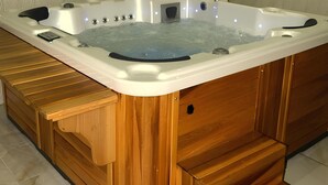 A hot tub with wooden steps leading up to it, surrounded by tiled walls. - Tera Life Thermal Hotel (Kozakli)