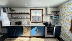Una cucina moderna con piastrelle bianche a metro, mobili azzurri e una parete di fondo decorata.