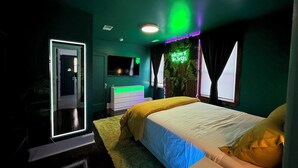 Una camera da letto con un letto, una cassettiera, una TV e un'insegna luminosa al neon.