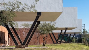 En moderne bygning med et unikt arkitektonisk design, med store betonpaneler støttet af sorte metalbjælker.