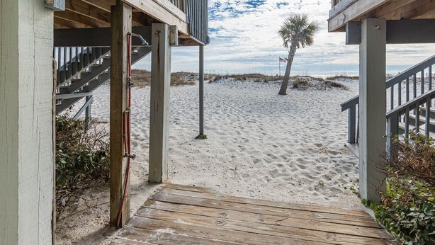 A wooden staircase leading to a beach area with a palm tree and a sandy path. - Newly Renovated Beachside Complex~2BR/1.5B w/Pool (Gulf Shores)