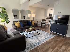 A modern living room with a sofa, coffee table, and a TV.