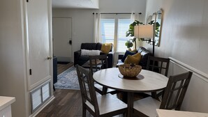 A dining area with a round table, chairs, and a central woven basket. - Newly Renovated Beachside Complex~2BR/1.5B w/Pool (Gulf Shores)