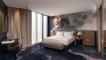 Une chambre d’hôtel moderne avec un grand lit, un bureau et une vue sur la ville.