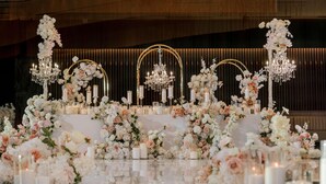 Ein luxuriöser Rahmen mit spiegelndem Boden, stilvollen Blumenarrangements und Kristalllüstern.