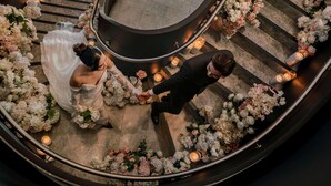 Eine Hochzeitszeremonie auf einer geschwungenen Treppe mit Blumenarrangements und Kerzen.