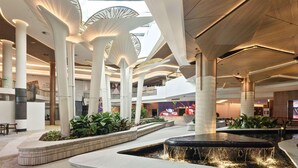 A spacious indoor area with high ceilings, large columns, and a central water feature. - Novotel Sydney Cabramatta (Sydney)