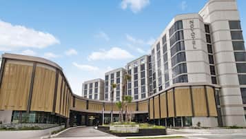A modern hotel with a curved facade, multiple floors, and a prominent 'NOVOTEL' sign.