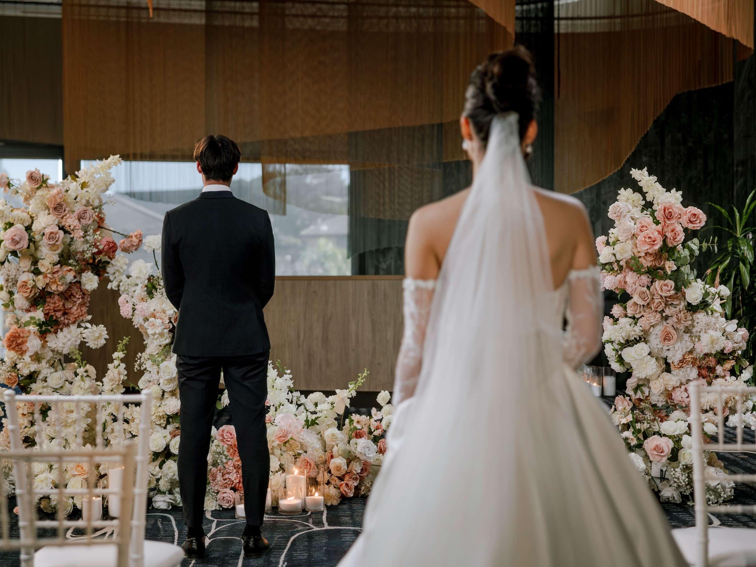 A wedding ceremony with floral decorations and a modern interior.
