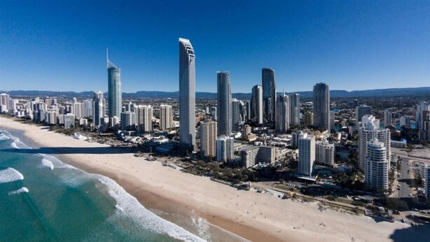 Un paysage urbain côtier avec de hauts immeubles qui bordent une plage de sable.