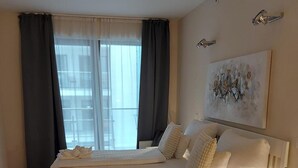 Un dormitorio con dos camas, una mesita de noche, una lámpara y un cuadro en la pared.