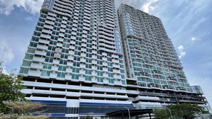 A high-rise building with a modern architectural design, featuring multiple balconies and a prominent glass facade. - Howard Johnson By Wyndham Tangerang (Tangerang)