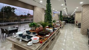 A buffet setup with various food items and a long serving table. - Howard Johnson By Wyndham Tangerang (Tangerang)